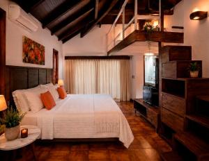 a bedroom with a large bed and a television at La Locanda Art & Taste Retreat in Puerto Iguazú +60 photos