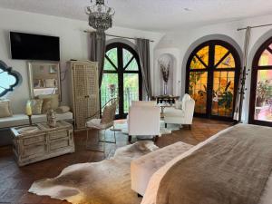 a bedroom with a large bed and a living room at Tres Fuentes Hotel Boutique in San Miguel de Allende