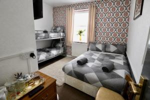 a small bedroom with a bed and a window at Blackpool Central Lodge in Blackpool