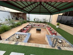 an outdoor patio with couches and rocks and a building at Rawnaq aljabal chalet in Qurayyah