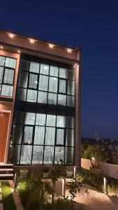 a large building with a lot of windows at night at Rawnaq aljabal chalet in Qurayyah