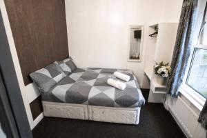 a small bedroom with a bed and a mirror at Blackpool Central Lodge in Blackpool +6 photos