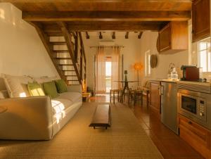 ein Wohnzimmer mit Sofa und eine Küche in der Unterkunft Monte do Alento - Castro da Cola in Alcaria