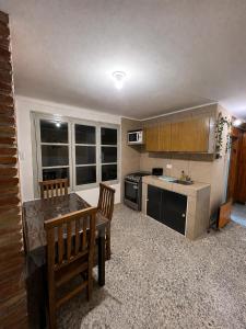 a kitchen with a table and two chairs and a counter at Alojamiento LowCost San Rafael in San Rafael