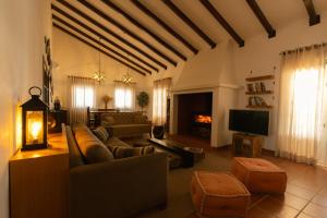 ein Wohnzimmer mit Sofas, Fernseher und Kamin in der Unterkunft Monte do Alento - Castro da Cola in Alcaria