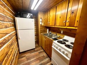 a kitchen with a white refrigerator and a sink at Caribou Cabin -Rustic Cabin with Sauna in Delta Junction