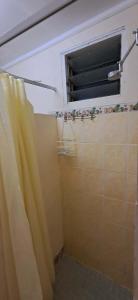 a bathroom with a window and a shower curtain at Talanoa Fales Accommodation in Apia