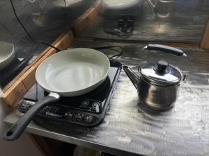 a bowl sitting on top of a stove with a pot at Aoi-Yane Traditional Japanese House in Kumano Kodo Nakahechi in Tanabe