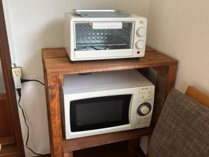 a microwave and a toaster oven on a table at Aoi-Yane Traditional Japanese House in Kumano Kodo Nakahechi in Tanabe