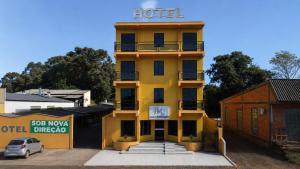 a yellow hotel with a sign on top of it at hotel Maanaim in Candói
