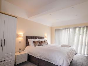 a bedroom with a large bed and a window at Millmoss Cottage in Turriff