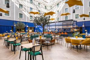 a view of the restaurant with tables and chairs at voco Gent by IHG in Ghent