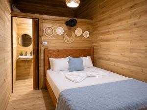 a bedroom with a bed in a wooden room at Palmarío Beach House in Guachaca