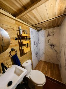 a bathroom with a toilet and a sink at Palmarío Beach House in Guachaca