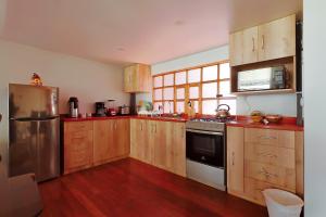 a kitchen with wooden cabinets and stainless steel appliances at Sumaq Sisa Home & Loft in Cusco