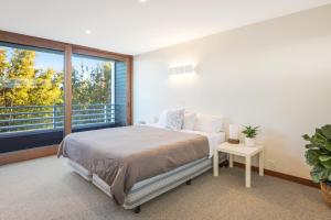 a bedroom with a bed and a large window at East Lane in Tathra +61 photos