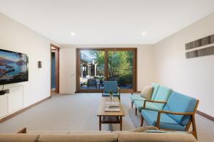 a living room with a couch and chairs and a tv at East Lane in Tathra