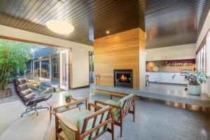 a living room with a fireplace and wooden ceilings at East Lane in Tathra