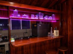 a bar with purple lighting in a kitchen at Maye WOOD APT in Uvita
