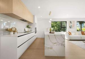a kitchen with white counters and a couch in a room at Duo Duo in Auckland