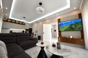 a living room with a couch and a large screen tv at Lavéa Villa in Draç