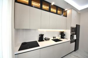 a kitchen with white cabinets and a sink at Lavéa Villa in Draç