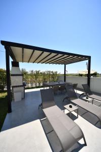 a patio with chairs and tables and a pavilion at Lavéa Villa in Draç