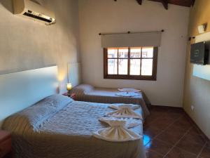 a bedroom with two beds and a window at Hotel Argentina in Mina Clavero +24 photos