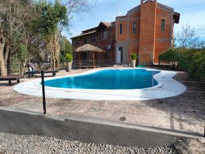 a swimming pool in front of a house at Hotel Argentina in Mina Clavero