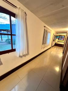 a hallway with white walls and a large window at Hotel Argentina in Mina Clavero