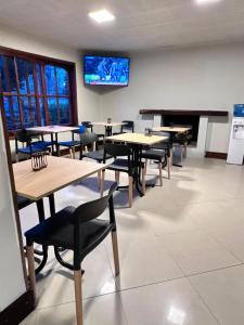 a room with tables and chairs and a piano at Hotel Argentina in Mina Clavero