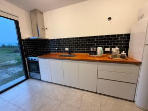 a kitchen with white cabinets and a counter with a sink at Casa Marti in Los Reartes