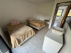 a small bedroom with two beds and a mirror at Casa Marti in Los Reartes