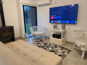 a living room with a couch and a tv on the wall at Casa Marti in Los Reartes