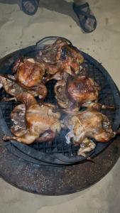 a bunch of chickens cooking on a grill at مخيم همسات الصحراء in Siwa