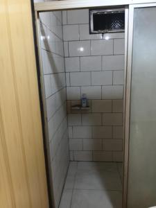a small bathroom with a shower with white tiles at Maye WOOD APT in Uvita +39 photos