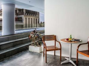a room with a table and chairs and a large window at The Kuta Beach Heritage Hotel - Managed by Accor in Kuta