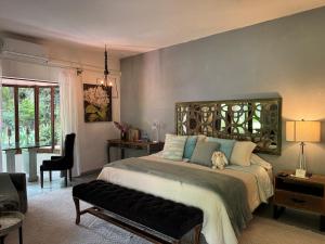 a bedroom with a large bed and a chair at Tres Fuentes Hotel Boutique in San Miguel de Allende +83 photos