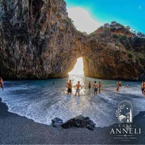 a group of people standing in the water at a beach at Casa Anneli - Scalea Park 2000 in Scalea