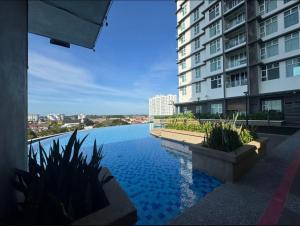 a view of a swimming pool in front of a building at Crystal Studio Apartment D'Perdana in Kota Bharu
