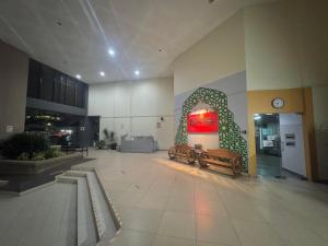 a lobby with two benches and a clock on the wall at Crystal Studio Apartment D'Perdana in Kota Bharu