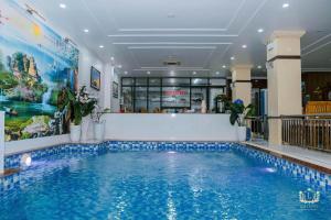 a swimming pool in a hotel room with a large swimming pool at Lux Hotel FLC Sầm Sơn in Sầm Sơn