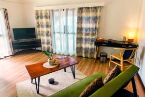 a living room with a green couch and a table at Balai sa Baibai in Mambajao