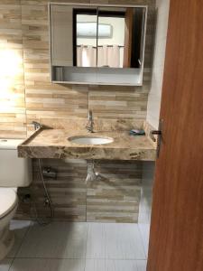 a bathroom with a sink and a mirror and a toilet at Refúgio em Jacumã Conforto, Tranquilidade e Praia in Conde +9 photos