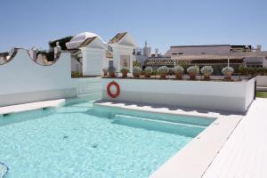 einen Pool im Hinterhof eines Hauses in der Unterkunft Hotel Las Casas de la Judería in Sevilla