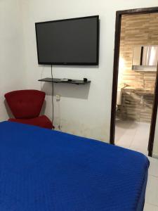 a bedroom with a bed and a flat screen tv at Refúgio em Jacumã Conforto, Tranquilidade e Praia in Conde
