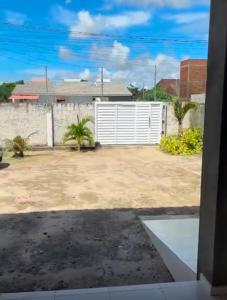 a view of a yard with a white fence at Refúgio em Jacumã Conforto, Tranquilidade e Praia in Conde