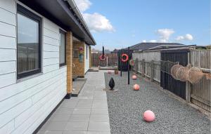 a patio with balls on the ground next to a building at Awesome Home In Thyborøn With Wifi in Thyborøn