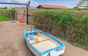 a small boat sitting on the ground with a swing at Awesome Home In Thyborøn With Wifi in Thyborøn +12 photos