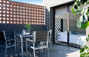 a patio with a table and chairs and a bed at Eric Vökel Boutique Apartments - BCN Suites in Barcelona